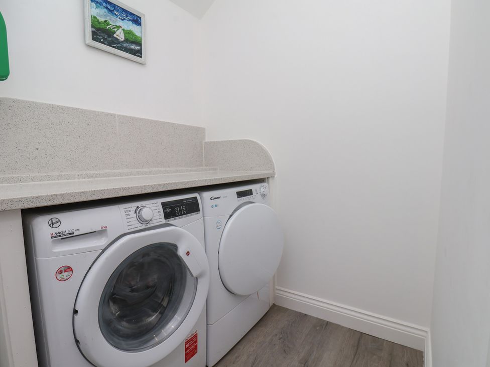 A laundry room with a washing machine and tumble dryer at Reighton House in Reighton near Filey
