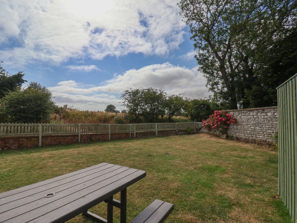 A garden with a table and flowers at Reighton House in Reighton near Filey