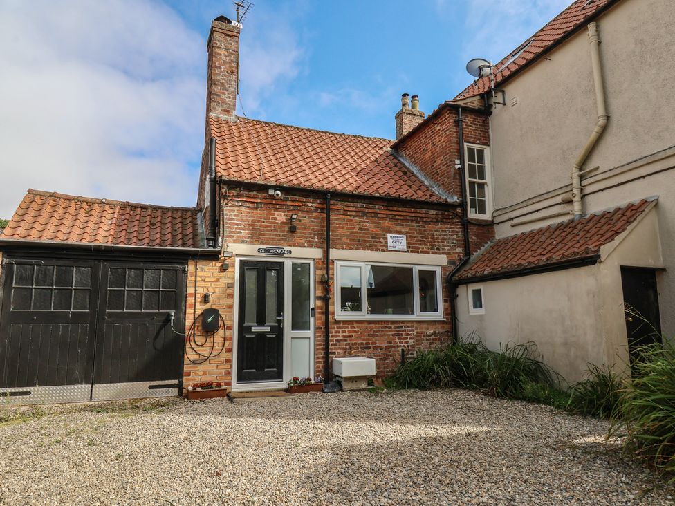 A house with a garage and gravel driveway at Reighton House in Reighton near Filey