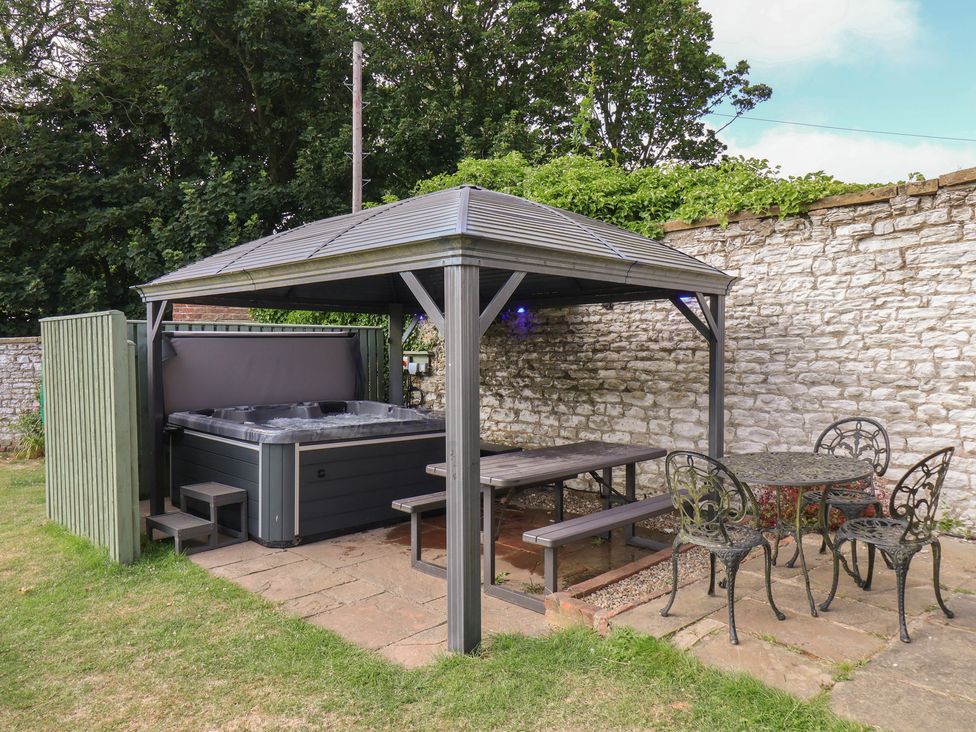 A garden with a hot tub and a seating area at Reighton House in Reighton near Filey