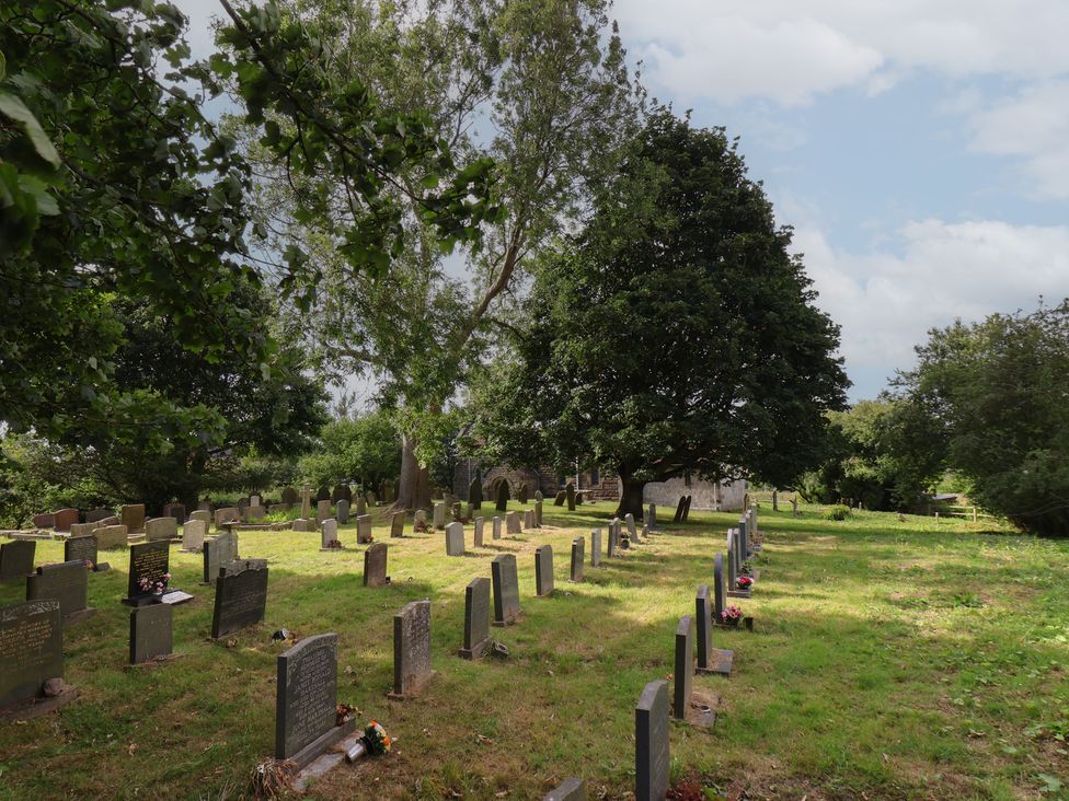 A cemetery with graves and trees at Reighton House in Reighton near Filey