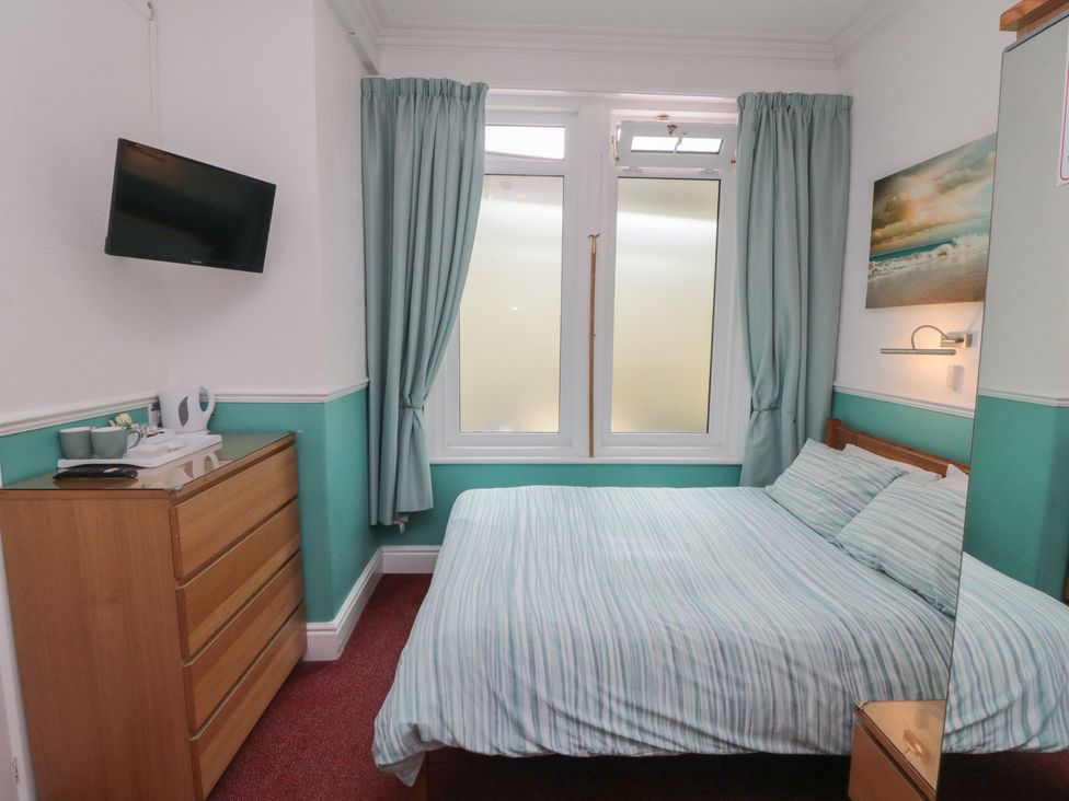 A bedroom with a bed and television at Meltham Guest House Scarborough