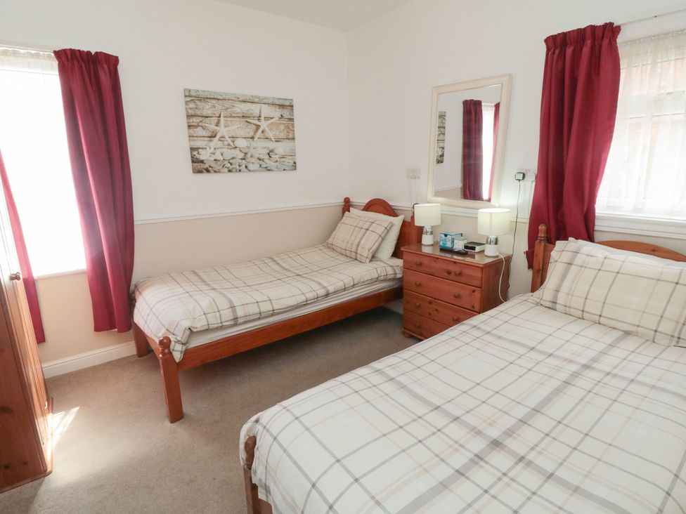 A bedroom with two beds and a bedside table at Meltham Guest House in Scarborough