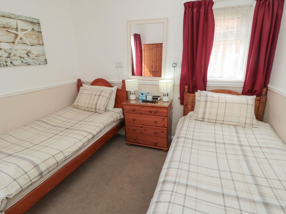 A bedroom with two beds and a chest of drawers at Meltham Guest House in Scarborough