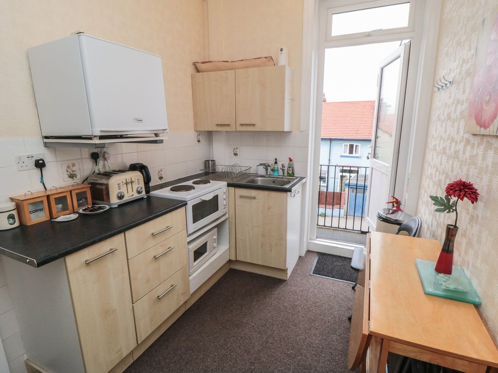 A kitchen with appliances and a table at Meltham Guest House in Scarborough