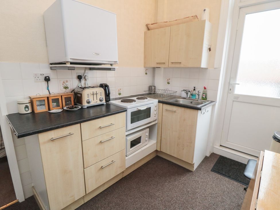 A kitchen with appliances and cabinets at Meltham Guest House in Scarborough