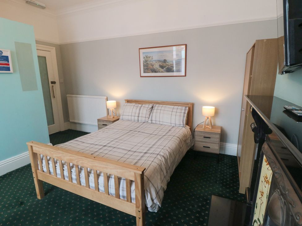 A bedroom with a bed and side tables at Meltham Guest House in Scarborough