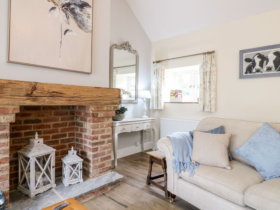 A living room with a sofa and fireplace at Churn Dash Cottage Derby