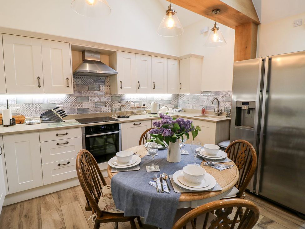 A kitchen with a dining table set at Churn Dash Cottage Derby