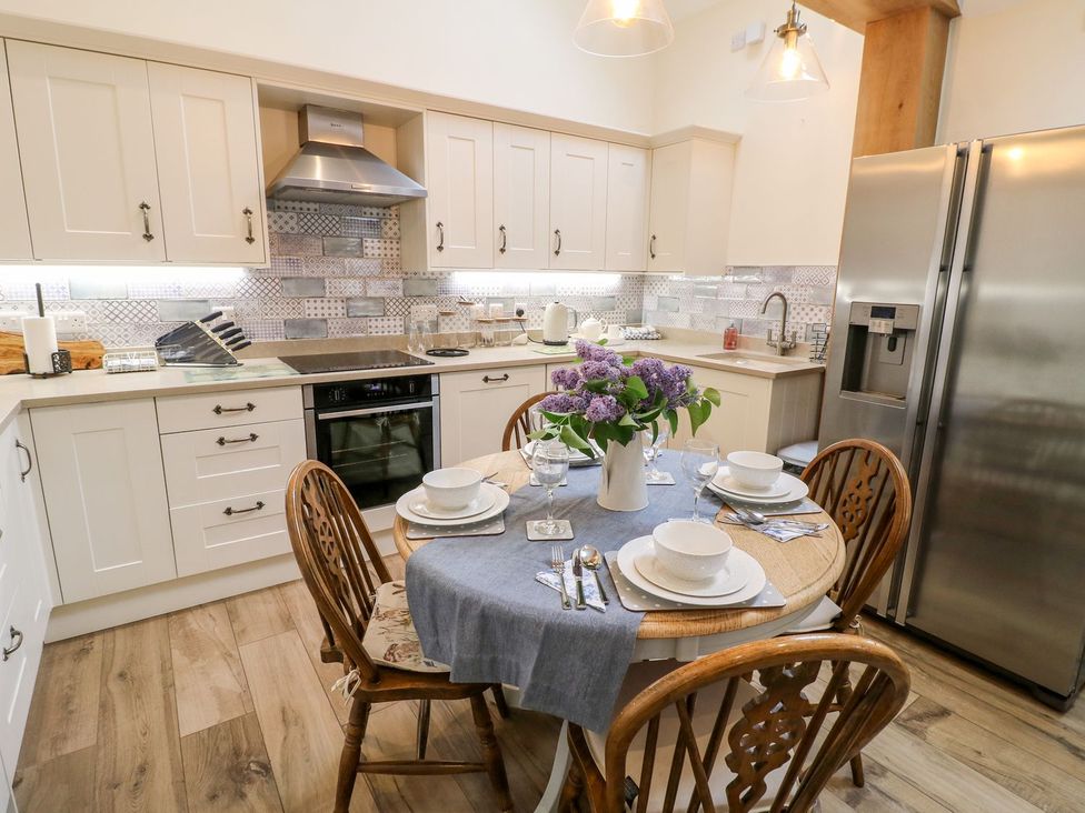 A kitchen with a table set for dining at Churn Dash Cottage in Derby