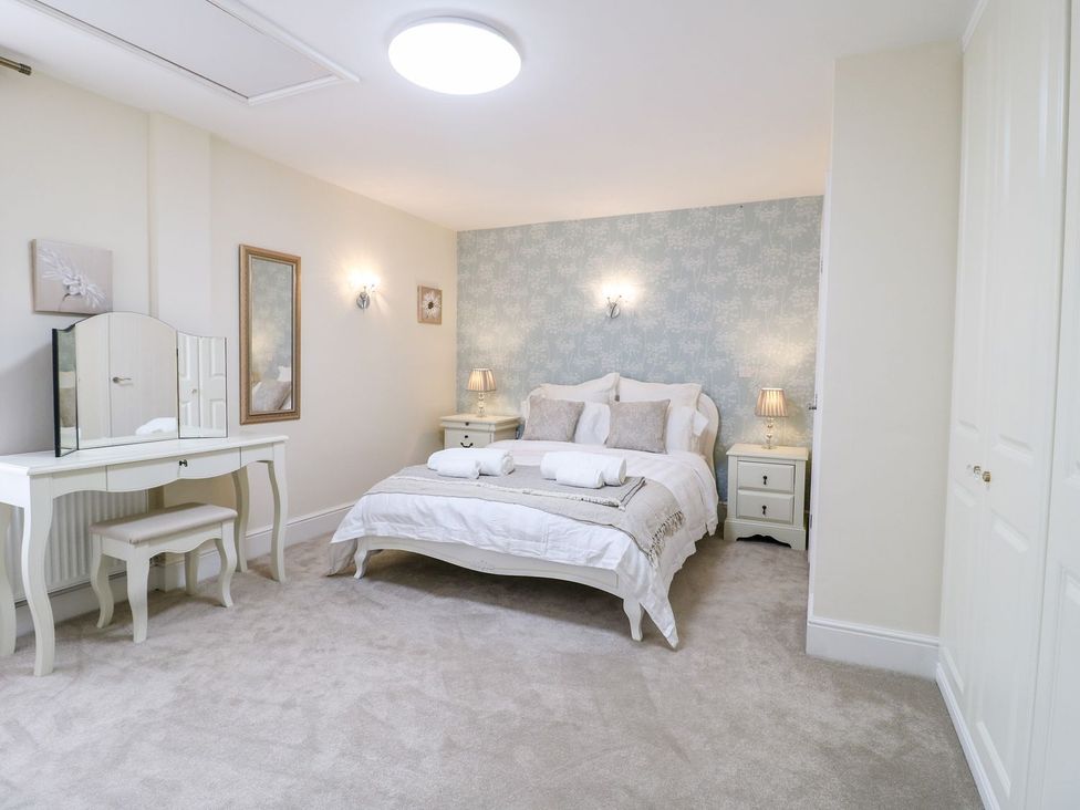 A bedroom with a bed and dresser at Churn Dash Cottage in Derby