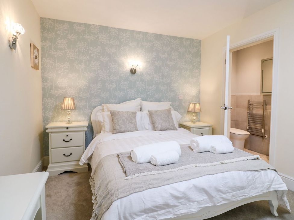A bedroom with a double bed and ensuite bathroom at Churn Dash Cottage Derby