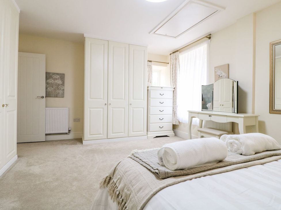 A bedroom with a bed and a dresser at Churn Dash Cottage in Derby