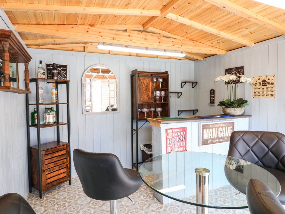 A man cave with bar and seating at Churn Dash Cottage Derby