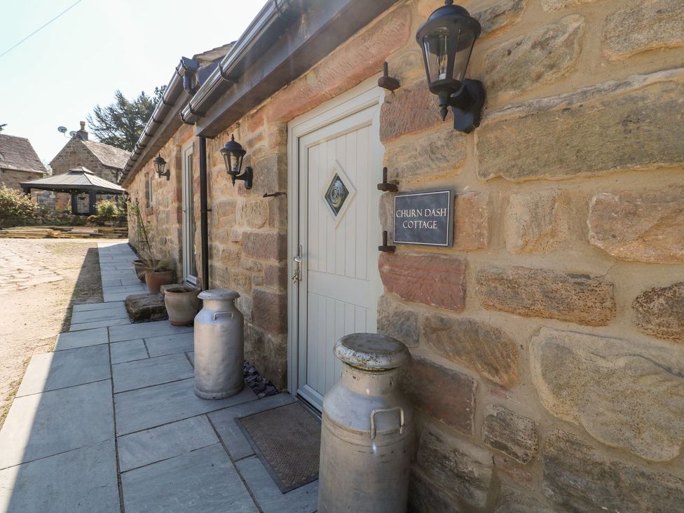 An entrance with a door and nameplate at Churn Dash Cottage in Derby