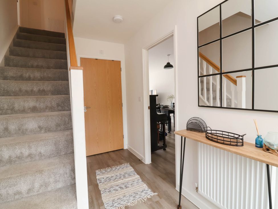 A hallway with stairs and a console table at 24 Higher Gorse Road Roughton