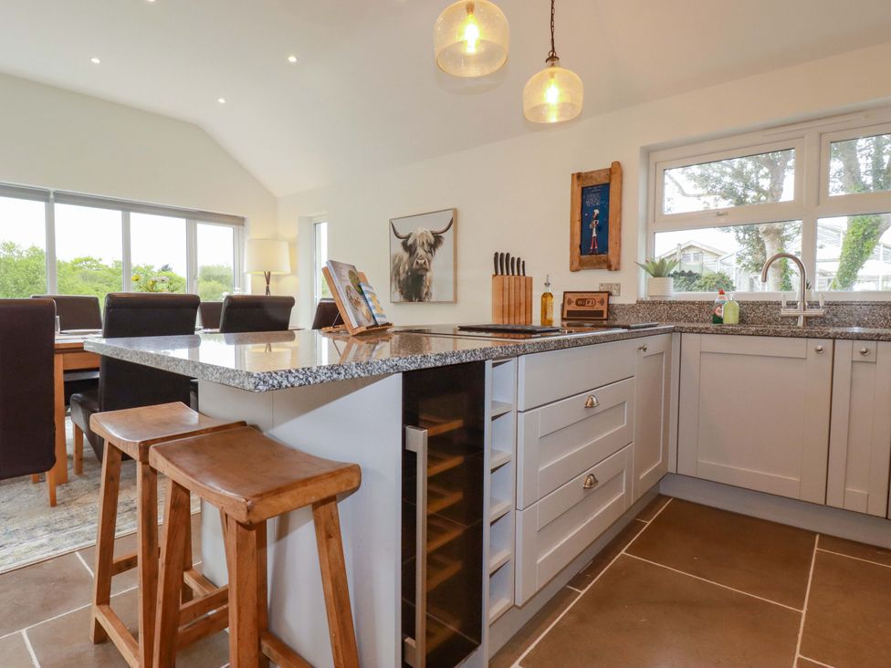 A kitchen with granite countertop and bar stools at Seveock in Threemilestone
