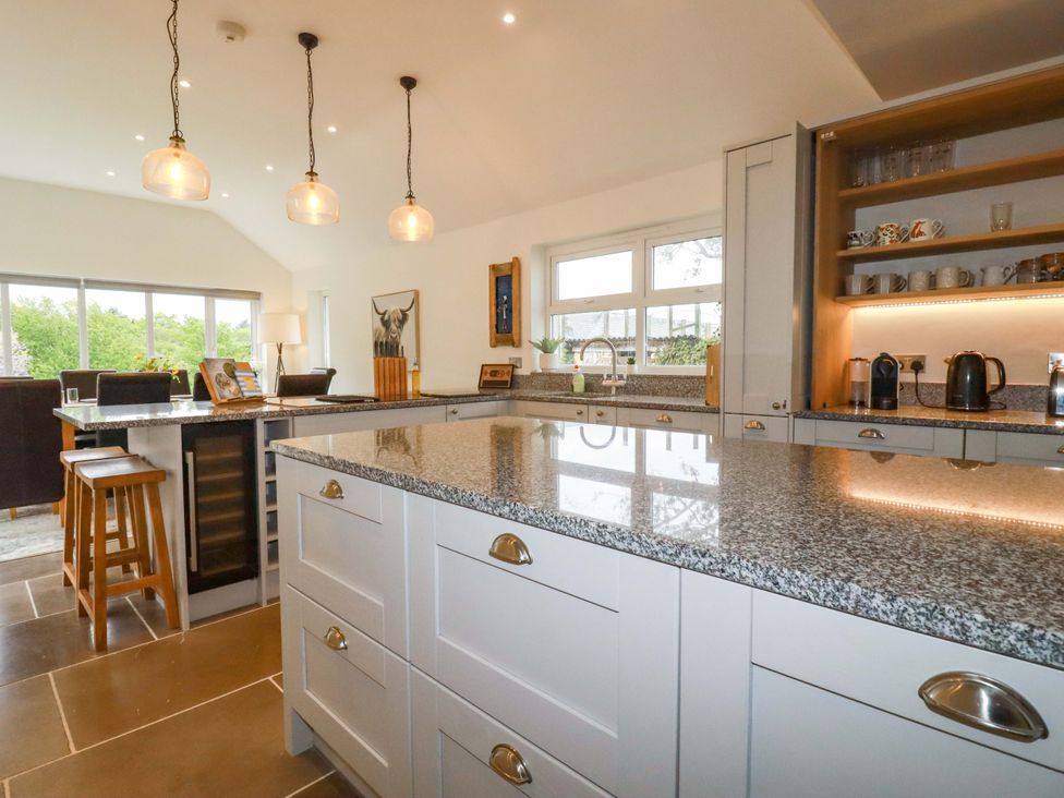 A kitchen with a large island and bar stools at Seveock in Threemilestone