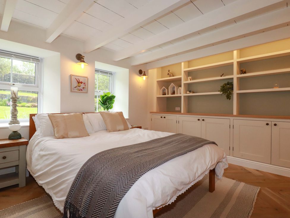 A bedroom with a bed and shelves at Seveock in Threemilestone