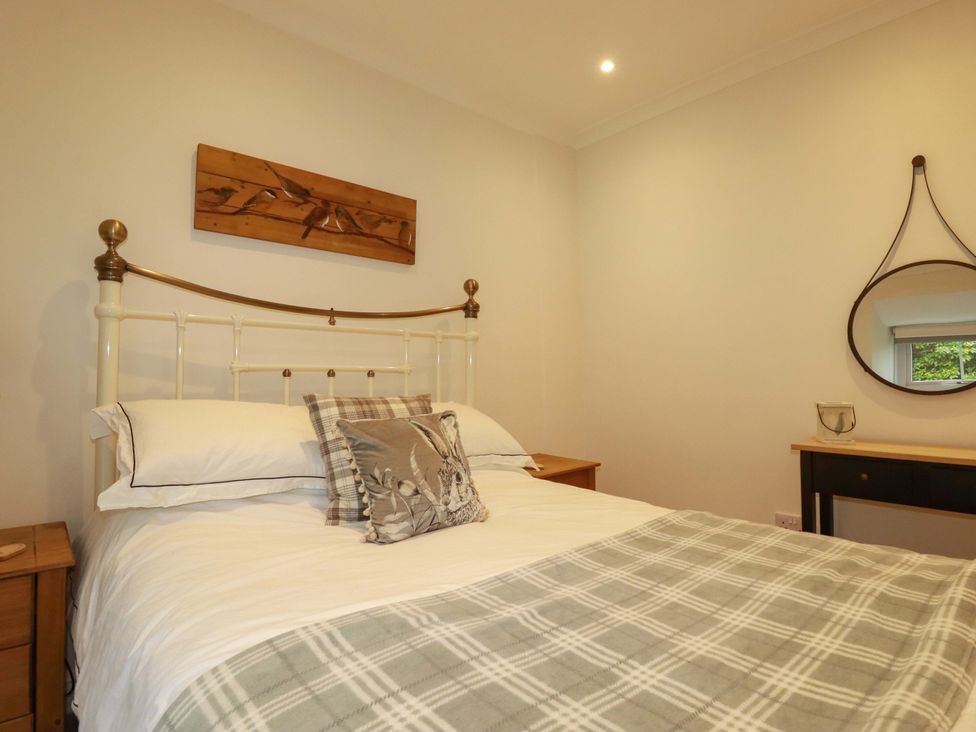 A bedroom with a bed and wooden furniture at Seveock in Threemilestone