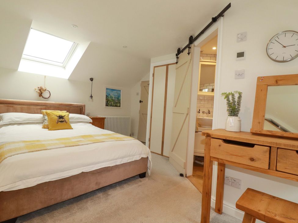 A bedroom with a bed and a sliding door leading to a bathroom at Seveock in Threemilestone