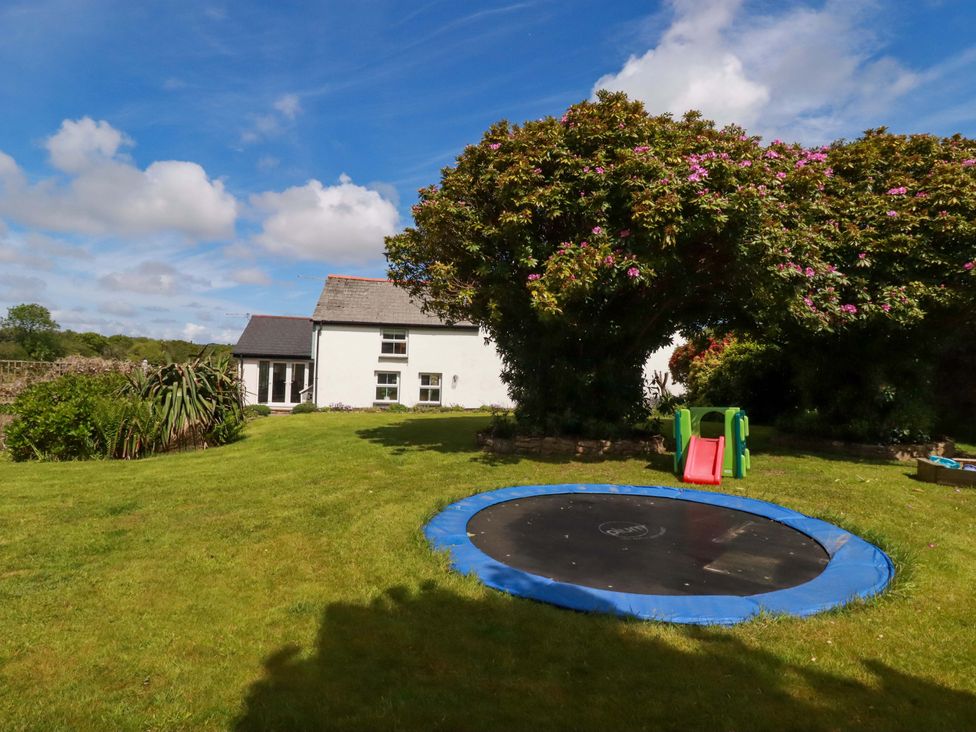 A garden with a trampoline and slide at Seveock in Threemilestone