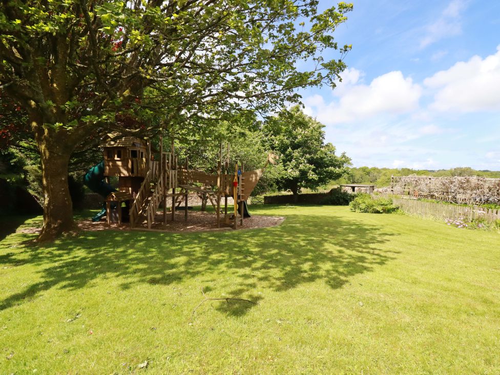A garden with a playhouse and tree at Seveock in Threemilestone