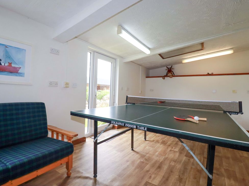 A games room with a ping pong table and seating at Seveock in Threemilestone