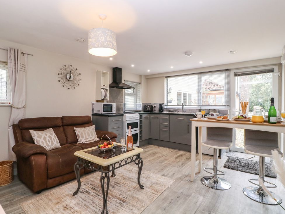 A kitchen with a sofa table and bar stools at Herriots Bridge Cottage Annex Bristol