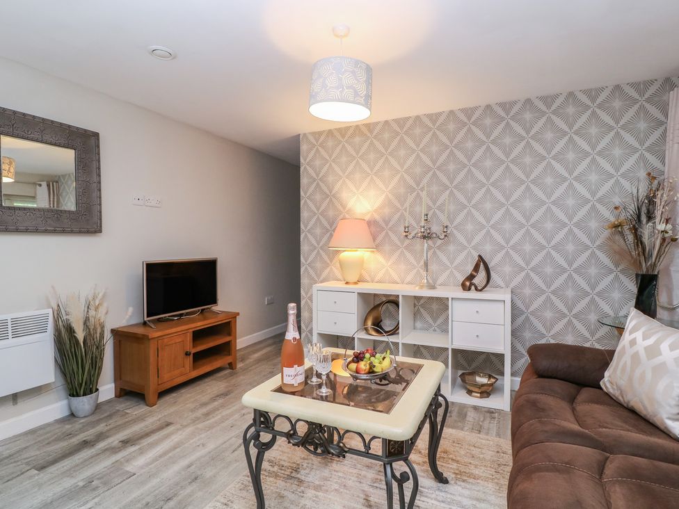 A living room with a sofa and television at Herriots Bridge Cottage Annex in Bristol