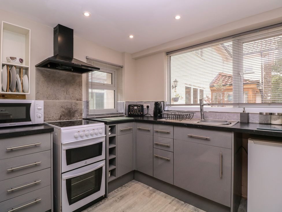A kitchen with stove, microwave, and sink at Herriots Bridge Cottage Annex in Bristol