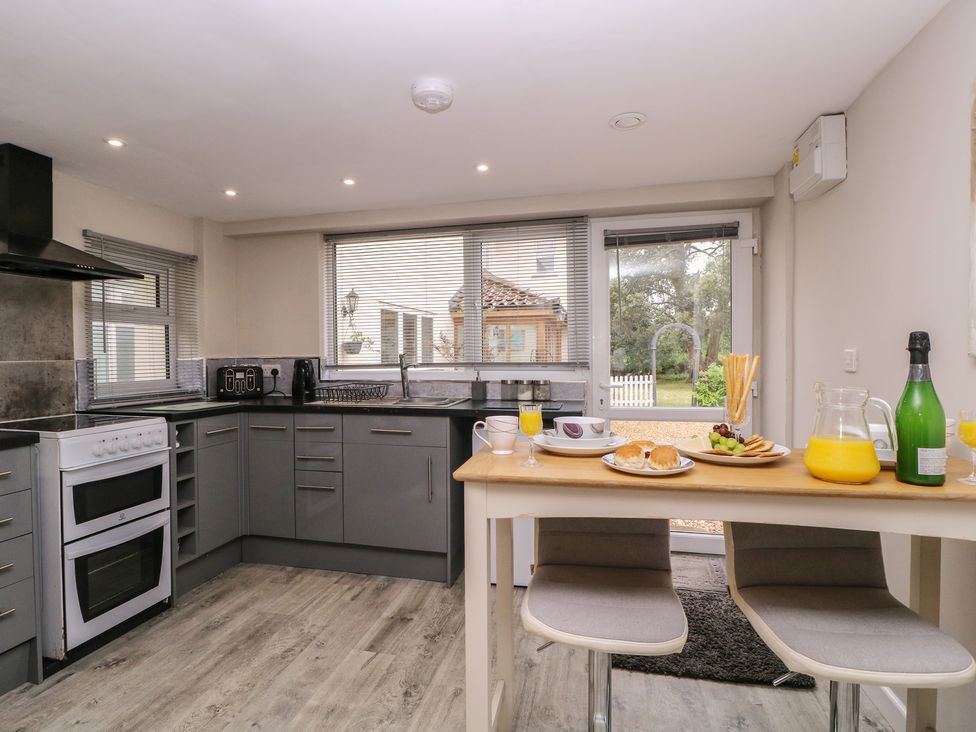 A kitchen with appliances and a dining table at Herriots Bridge Cottage Annex in Bristol