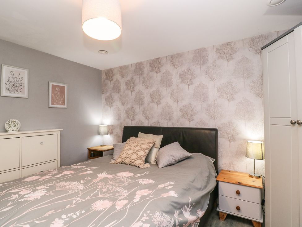 A bedroom with a bed and bedside table at Herriots Bridge Cottage Annex in Bristol
