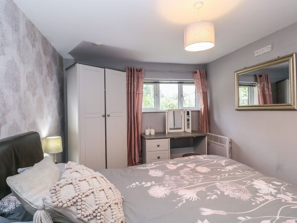 A bedroom with a bed and wardrobe at Herriots Bridge Cottage Annex in Bristol