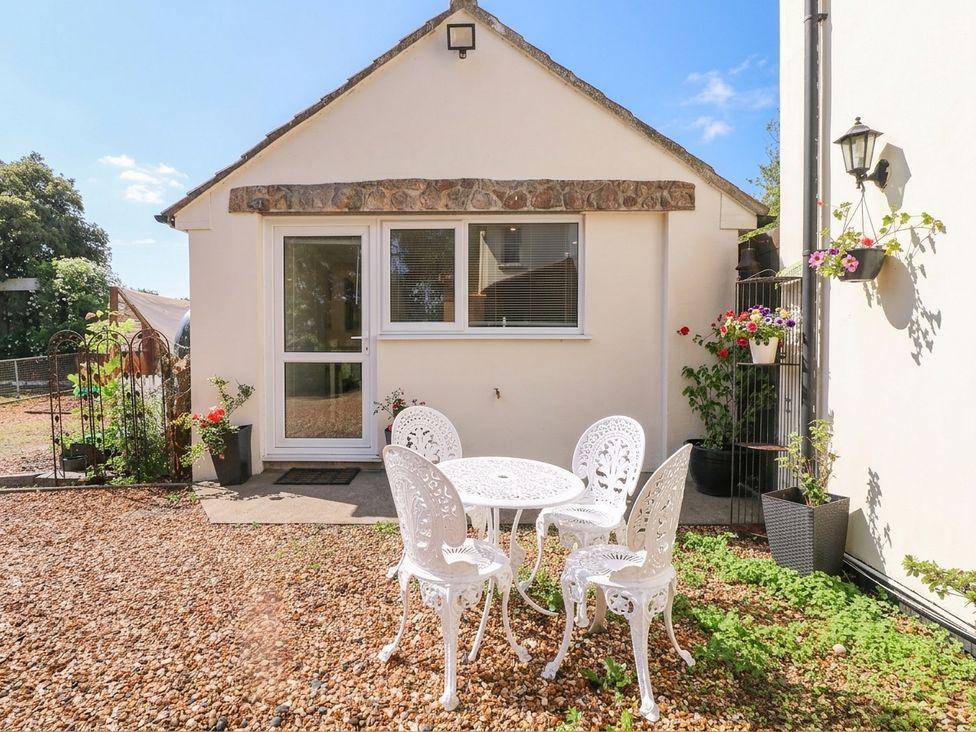 An outdoor seating area with chairs and a table at Herriots Bridge Cottage Annex in Bristol