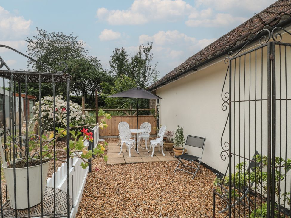 A garden with a table and chairs at Herriots Bridge Cottage Annex near Bishop Sutton