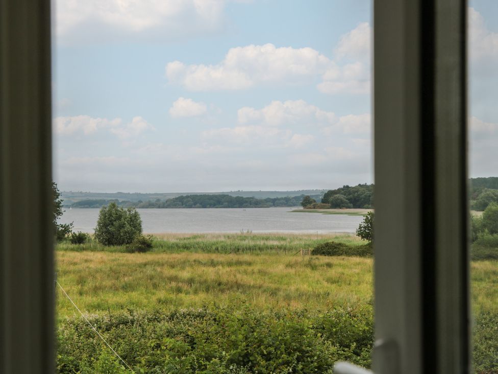 A view of water and trees from a window at Herriots Bridge Cottage Annex near Bishop Sutton