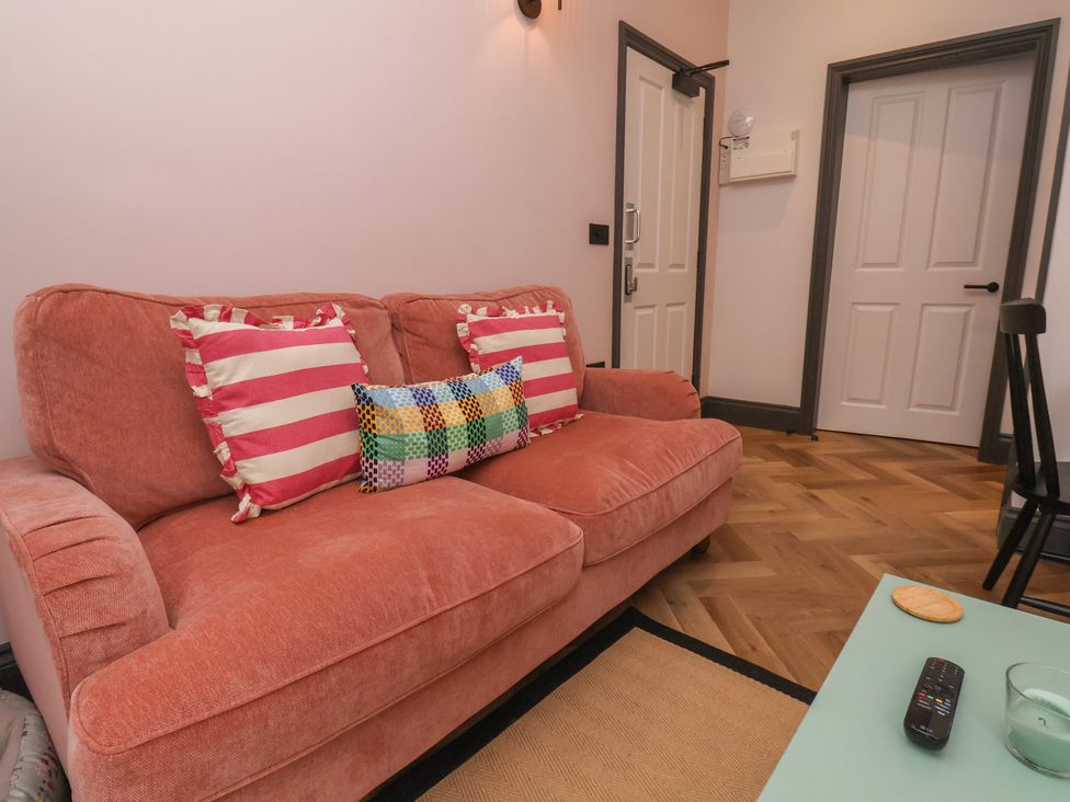 A living room with a pink sofa and pillows at Apartment Pink