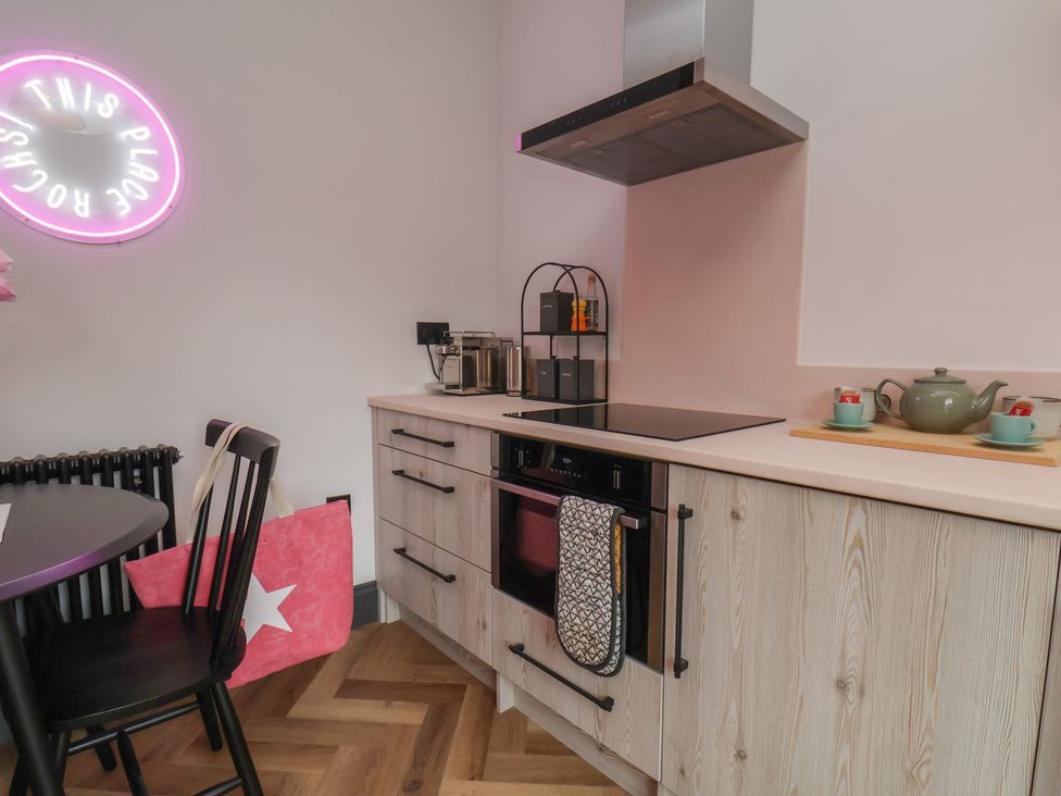 A kitchen with stove, sink, and teapot at Apartment Pink