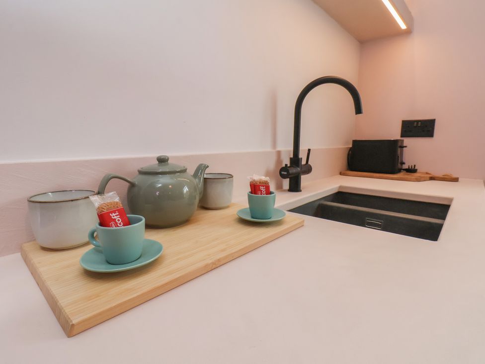 A kitchen counter with teapot and cups at Apartment Pink