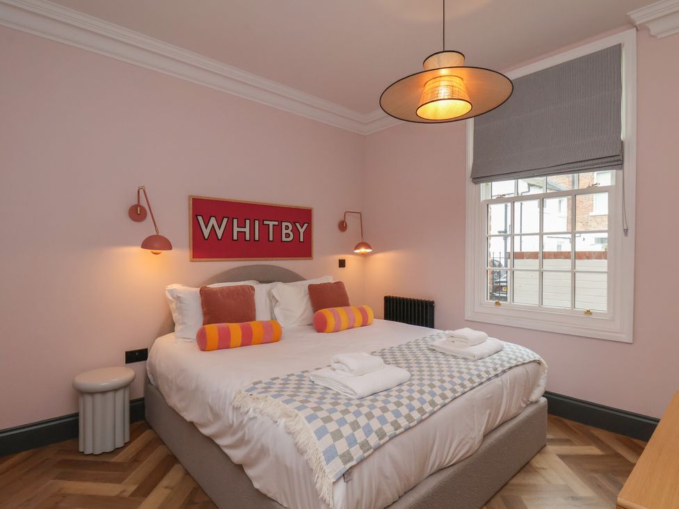 A bedroom with a bed and wall art at Apartment Pink