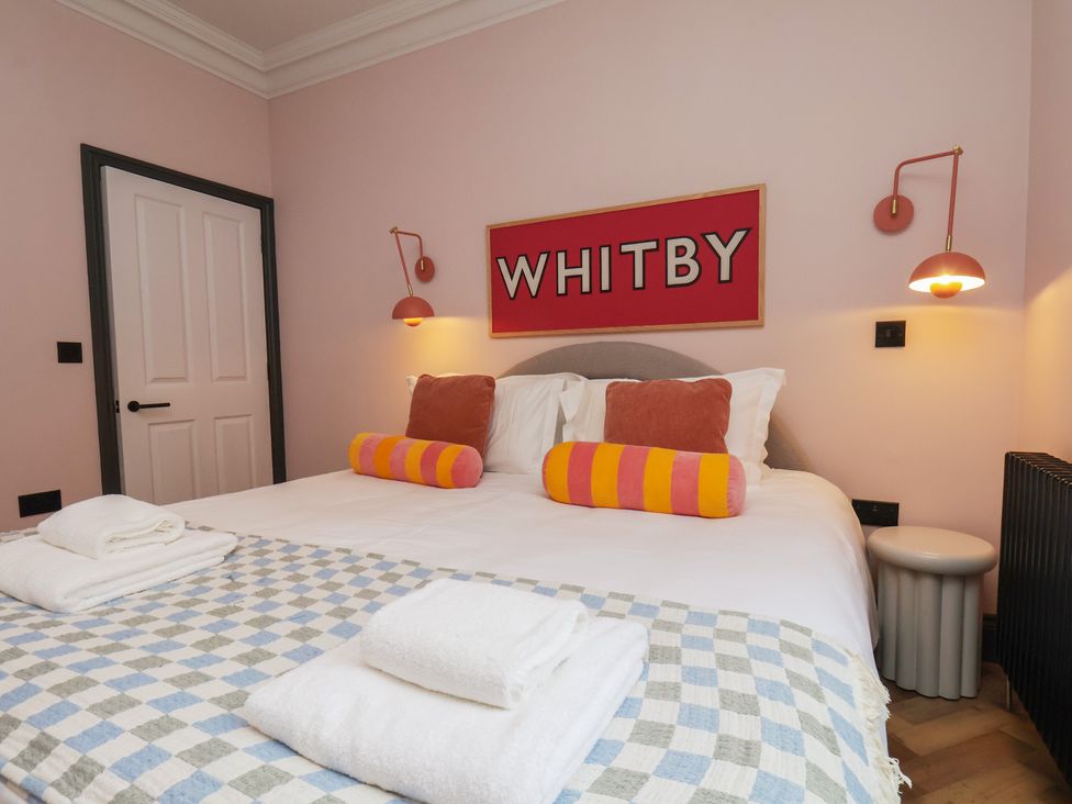 A bedroom with a bed and wall art at Apartment Pink