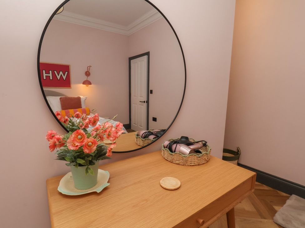 A bedroom with a mirror and a flower vase at Apartment Pink 