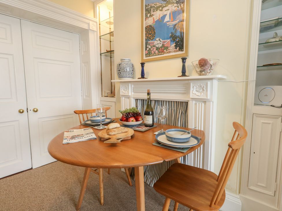 A dining room with a table set and fruit at No 3 By The Sea Weymouth
