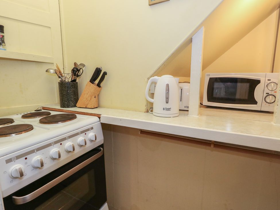 A kitchen with stove, microwave, kettle and utensils at No 3 By The Sea Weymouth