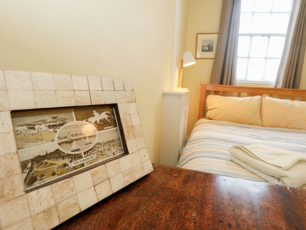 A bedroom with a bed and picture frame at No 3 By The Sea in Weymouth
