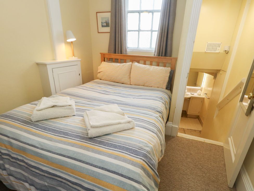 A bedroom with a bed and towels at No 3 By The Sea in Weymouth