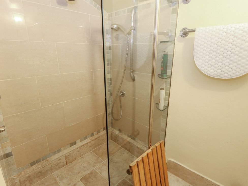 A shower with glass enclosure and showerhead at No 3 By The Sea in Weymouth