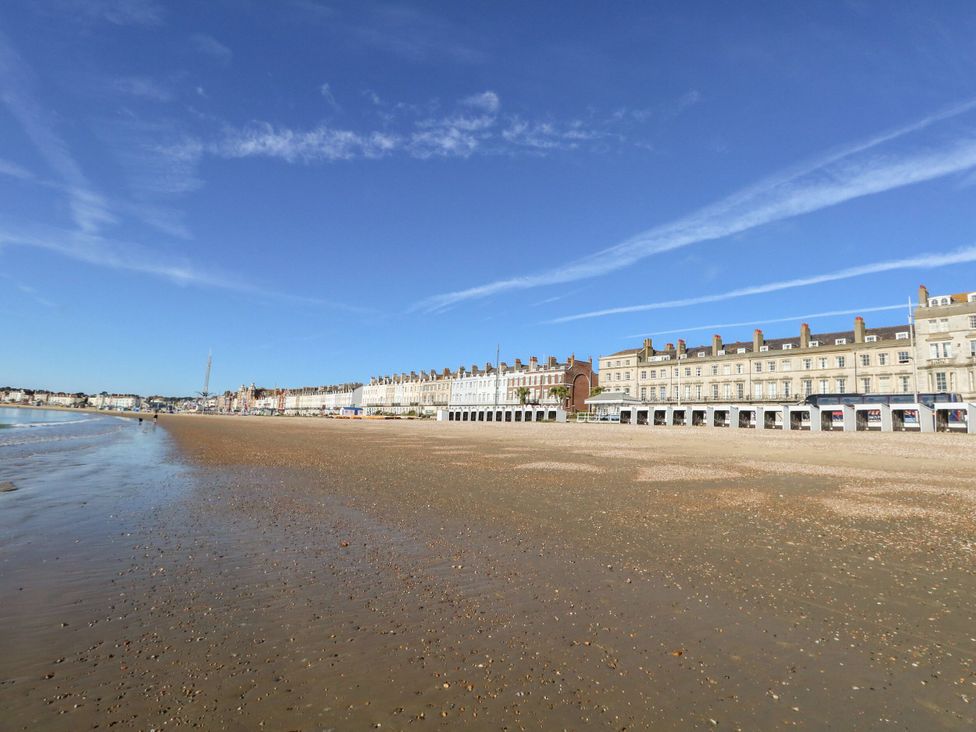 A beach with buildings along the shore at No 3 By The Sea in Weymouth