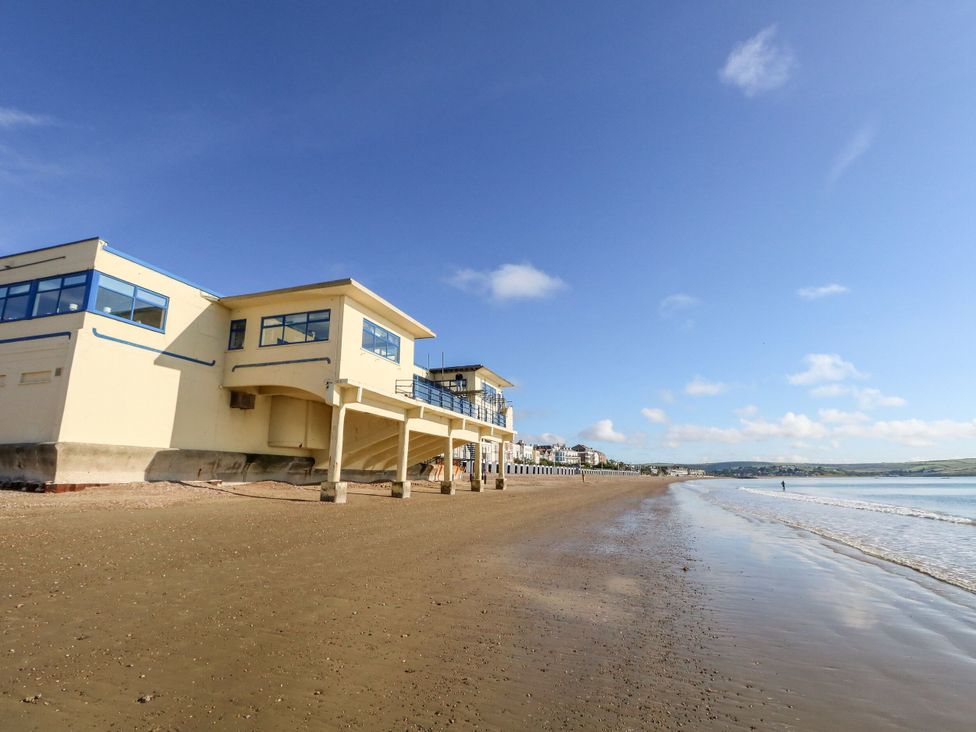 A beach with buildings beside it at No 3 By The Sea in Weymouth